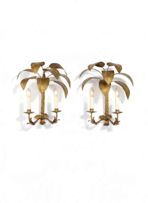 Pair of French gilt metal palm tree wall lights attributed to Maison Jansen, circa 1960, featuring sculptural tropical foliage, textured trunks, elegant twin candle arms and an aged gilt finish.